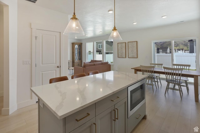 3030 S 400 W, Nibley, UT 84321 - kitchen featuring pendant lighting, a center island, light wood-type flooring, stainless steel microwave, and recessed lighting