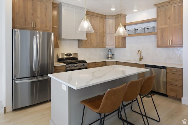 3030 S 400 W, Nibley, UT 84321 - kitchen with hanging light fixtures, appliances with stainless steel finishes, a breakfast bar, a sink, and a center island