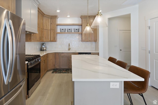 3030 S 400 W, Nibley, UT 84321 - kitchen with a kitchen breakfast bar, a center island, a sink, light wood finished floors, and appliances with stainless steel finishes
