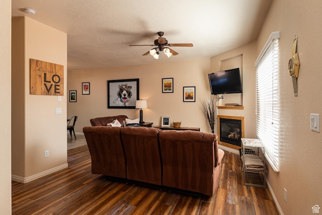 300 E 300 N Unit L5, Kanab, UT 84741 - living room with dark wood-style floors, ceiling fan, a glass covered fireplace, and baseboards