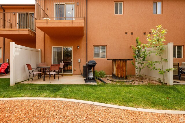 300 E 300 N Unit L5, Kanab, UT 84741 - rear view of house with a balcony, stucco siding, a patio area, and a yard