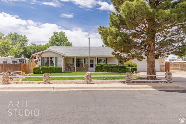 ranch-style home featuring concrete driveway, fence, and a front lawn