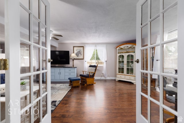living room with french doors, a ceiling fan, dark wood finished floors, and baseboards