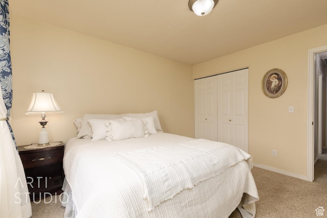 carpeted bedroom featuring baseboards and a closet