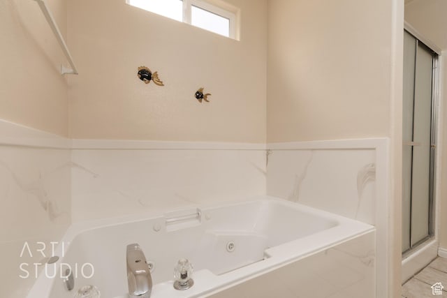 full bathroom with a tub with jets and a stall shower