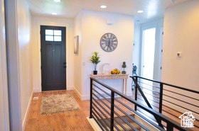 doorway with baseboards, recessed lighting, and wood finished floors