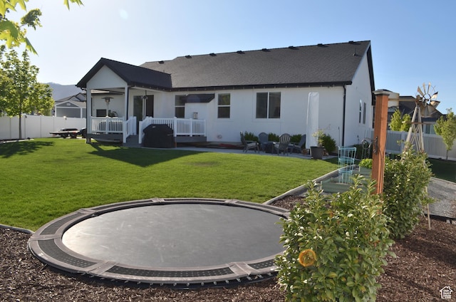 back of property featuring a lawn, roof with shingles, and fence