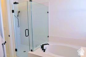 bathroom with a bath and a stall shower