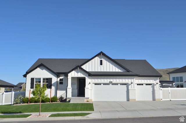modern inspired farmhouse with fence, an attached garage, a front lawn, board and batten siding, and driveway