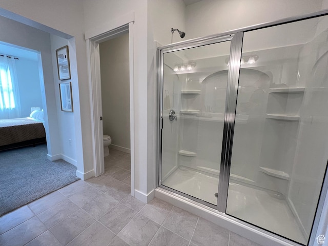 full bath with baseboards, connected bathroom, a stall shower, and toilet