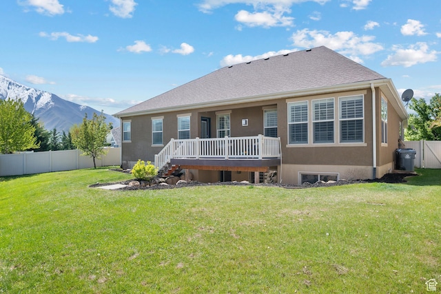 927 S Iris Ln W, Mapleton, UT 84664 - rear view of house with stucco siding, a fenced backyard, a deck with mountain view, and a yard