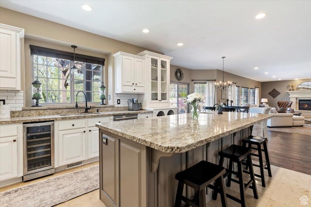 2077 E Genova Dr S, Draper, UT 84020 - kitchen with backsplash, a kitchen bar, a sink, open floor plan, and wine cooler