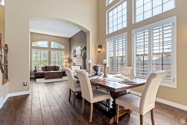 2077 E Genova Dr S, Draper, UT 84020 - dining space featuring wood-type flooring, arched walkways, baseboards, and a fireplace