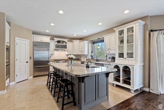 2077 E Genova Dr S, Draper, UT 84020 - kitchen featuring appliances with stainless steel finishes, backsplash, a center island with sink, and a kitchen breakfast bar