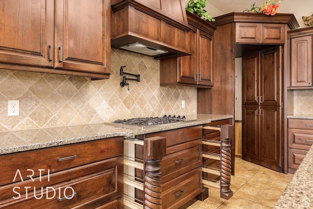 415 W Silver Hills Rd, Leeds, UT 84746 - kitchen featuring light tile patterned floors, light stone countertops, backsplash, custom range hood, and stainless steel gas cooktop