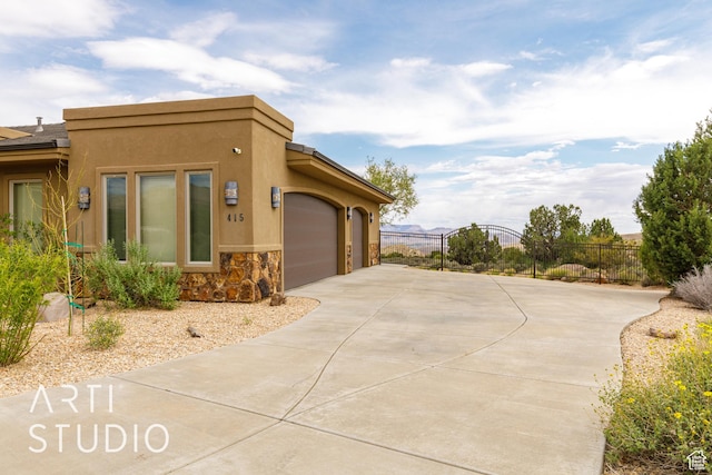415 W Silver Hills Rd, Leeds, UT 84746 - view of side of property featuring stone siding, a garage, stucco siding, fence, and driveway
