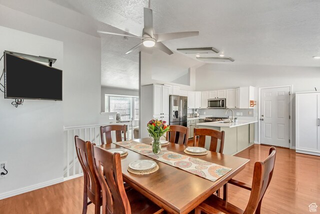 5943 N Genoa Ln W, Stansbury Park, UT 84074 - dining space featuring light wood-style floors, baseboards, ceiling fan, and vaulted ceiling