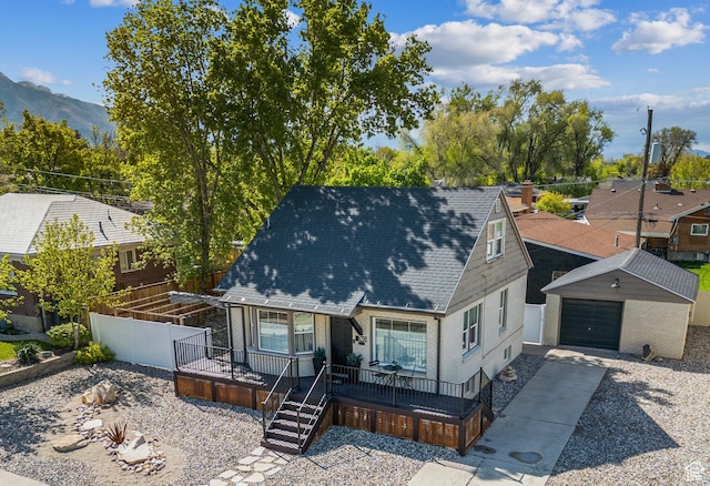 740 E Barrows Ave, Salt Lake City, UT 84106 - view of front facade featuring concrete driveway, a mountain view, roof with shingles, fence, and an outdoor structure