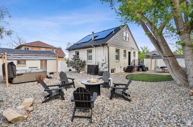 740 E Barrows Ave, Salt Lake City, UT 84106 - rear view of property with a fire pit, roof mounted solar panels, brick siding, a fenced backyard, and a hot tub