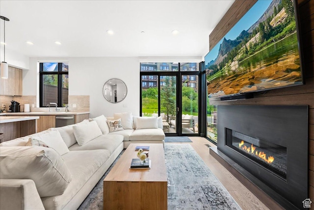 4134 Cooper Ln Unit 22, Park City, UT 84098 - living room with expansive windows, recessed lighting, a glass covered fireplace, and light wood-style flooring