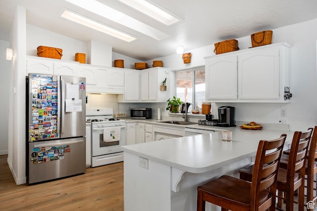 24517 W Rock Creek Rd, Duchesne, UT 84021 - kitchen with under cabinet range hood, a sink, a peninsula, lofted ceiling, and stainless steel appliances