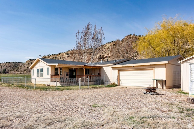 24517 W Rock Creek Rd, Duchesne, UT 84021 - view of front of house with fence private yard, a garage, a fire pit, a mountain view, and driveway