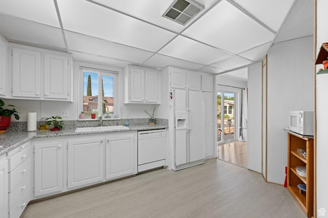 1526 N Dixie Downs Dr Unit 53, St George, UT 84770 - kitchen featuring visible vents, a sink, light wood finished floors, white appliances, and white cabinetry
