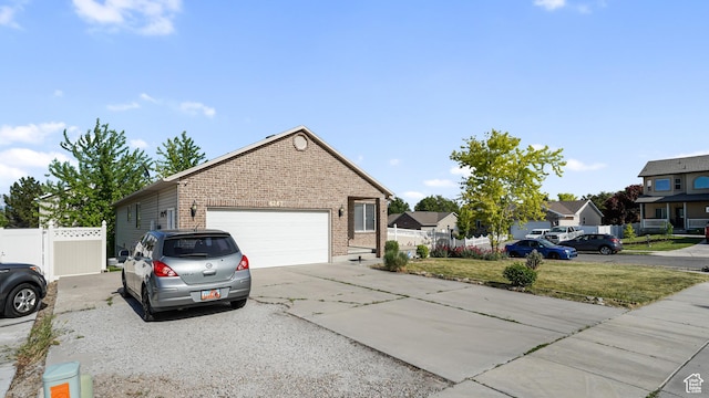 6267 S Waller Ln W, West Jordan, UT 84081 - view of home's exterior featuring brick siding, driveway, and a garage