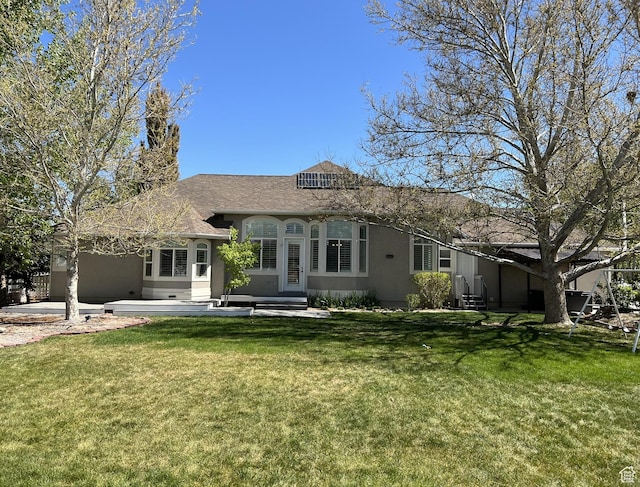 986 Davenport Dr S, Grantsville, UT 84029 - rear view of house with a lawn, entry steps, stucco siding, and a shingled roof