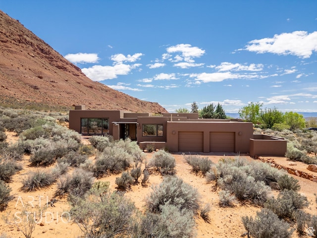 423 W Taman Ct, Ivins, UT 84738 - pueblo-style home with stucco siding, driveway, a mountain view, and a garage