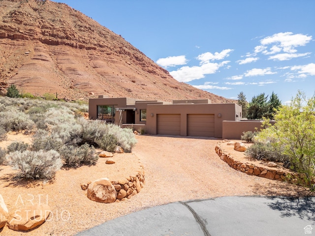 423 W Taman Ct, Ivins, UT 84738 - view of front facade with a mountain view, an attached garage, driveway, and stucco siding