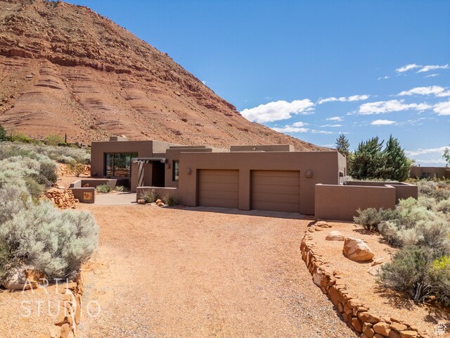 423 W Taman Ct, Ivins, UT 84738 - view of front of property featuring an attached garage, driveway, a mountain view, and stucco siding