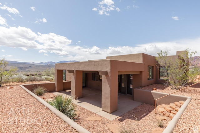 423 W Taman Ct, Ivins, UT 84738 - back of property with a mountain view, stucco siding, and a patio area
