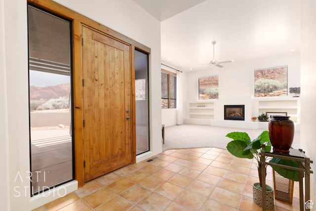 423 W Taman Ct, Ivins, UT 84738 - entryway featuring light carpet, a fireplace, a ceiling fan, light tile patterned floors, and visible vents