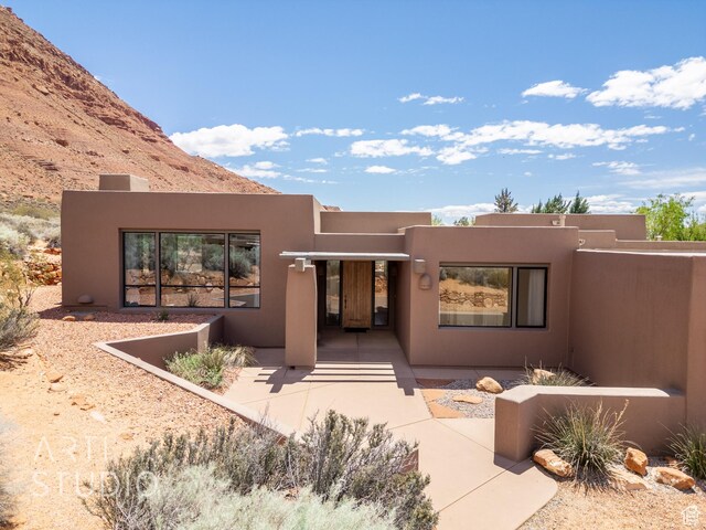 exterior space with a mountain view and stucco siding