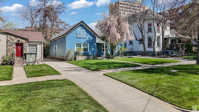 827 E 100 S, Salt Lake City, UT 84102 - view of front of house featuring concrete driveway, stone siding, and a front lawn