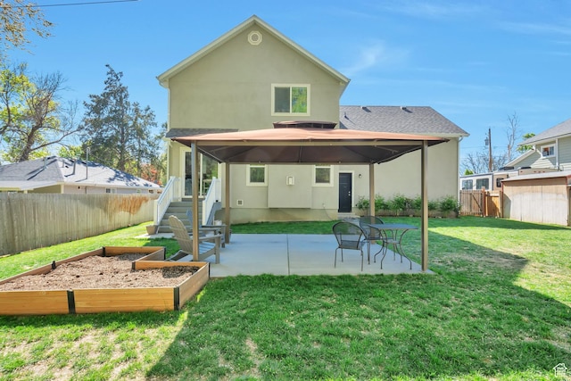 494 N 300 E, American Fork, UT 84003 - back of house featuring stucco siding, a vegetable garden, a fenced backyard, a patio area, and a yard