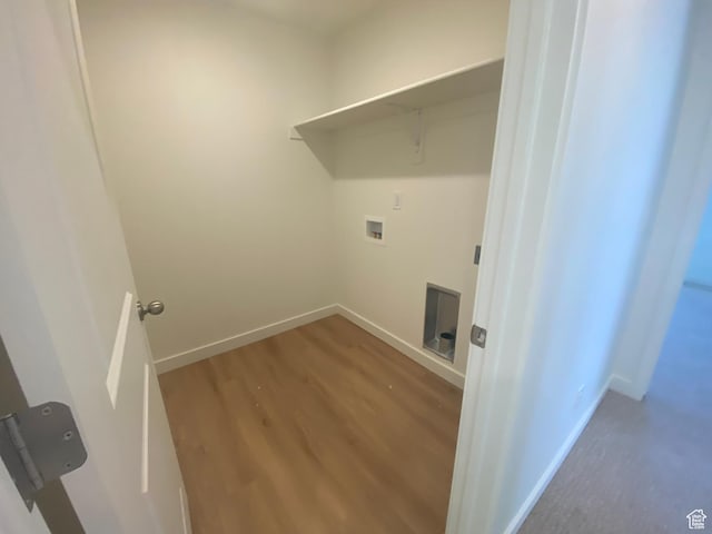 laundry area with baseboards, laundry area, washer hookup, and wood finished floors