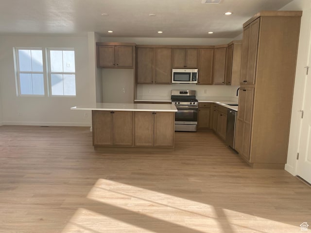 kitchen with baseboards, recessed lighting, light wood-style floors, and appliances with stainless steel finishes