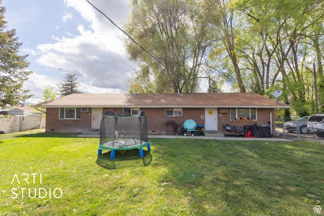 257 W 600 N, Lehi, UT 84043 - rear view of house with brick siding, a trampoline, fence, and a yard