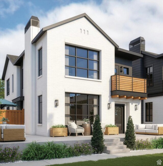 rear view of house featuring a chimney, an outdoor living space, and a balcony
