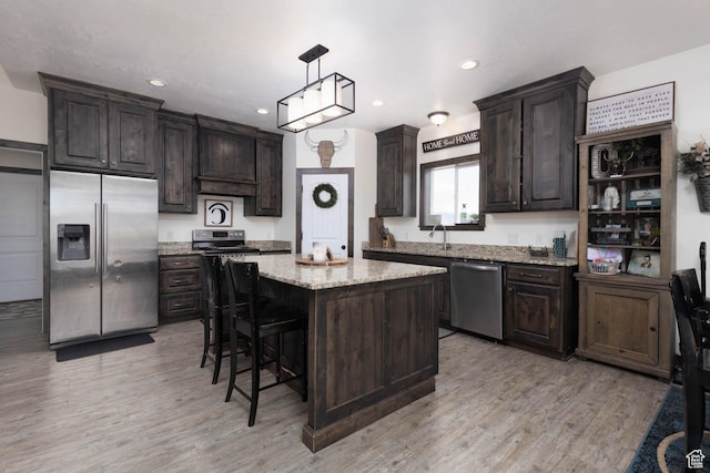 10360 S 10750 W, Axtell, UT 84621 - kitchen featuring light wood-style floors, appliances with stainless steel finishes, a kitchen island, and dark brown cabinets