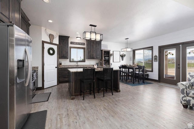 10360 S 10750 W, Axtell, UT 84621 - kitchen featuring dark brown cabinets, a breakfast bar, a center island, light wood finished floors, and appliances with stainless steel finishes