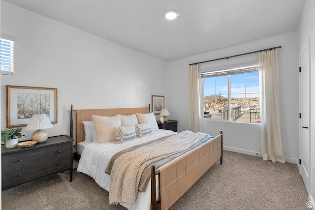 carpeted bedroom with baseboards and multiple windows