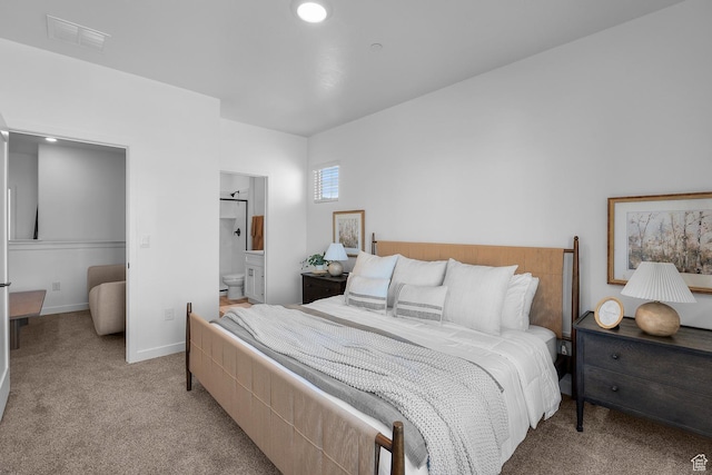 bedroom with light colored carpet, baseboards, ensuite bathroom, and visible vents