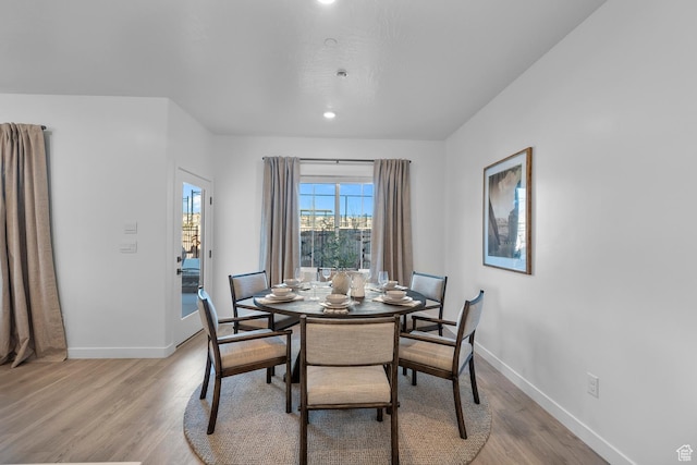 dining space featuring recessed lighting, baseboards, and light wood finished floors