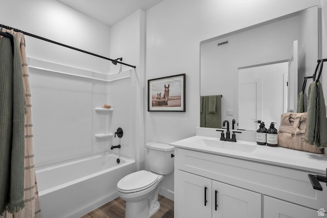 full bath with shower / bath combo, vanity, toilet, baseboards, and wood finished floors