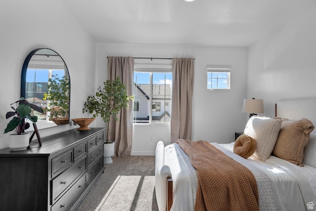 bedroom with baseboards and light colored carpet