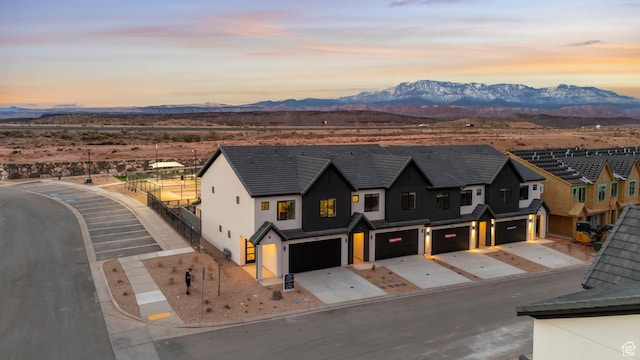 aerial view at dusk featuring a residential view and a mountain view