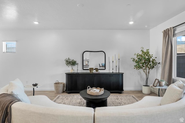 living room featuring recessed lighting, baseboards, and light wood finished floors